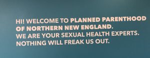 A sign on the wall of the new waiting room at Planned Parenthood reads, "Hi! Welcome to Planned Parenthood of Northern New England. We are your Sexual Health Experts. Nothing will freak us out."
