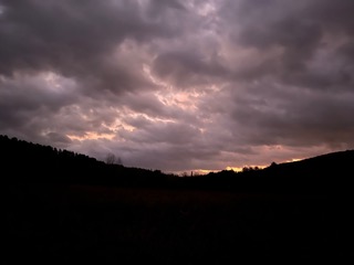 cloudy sky over dark hills